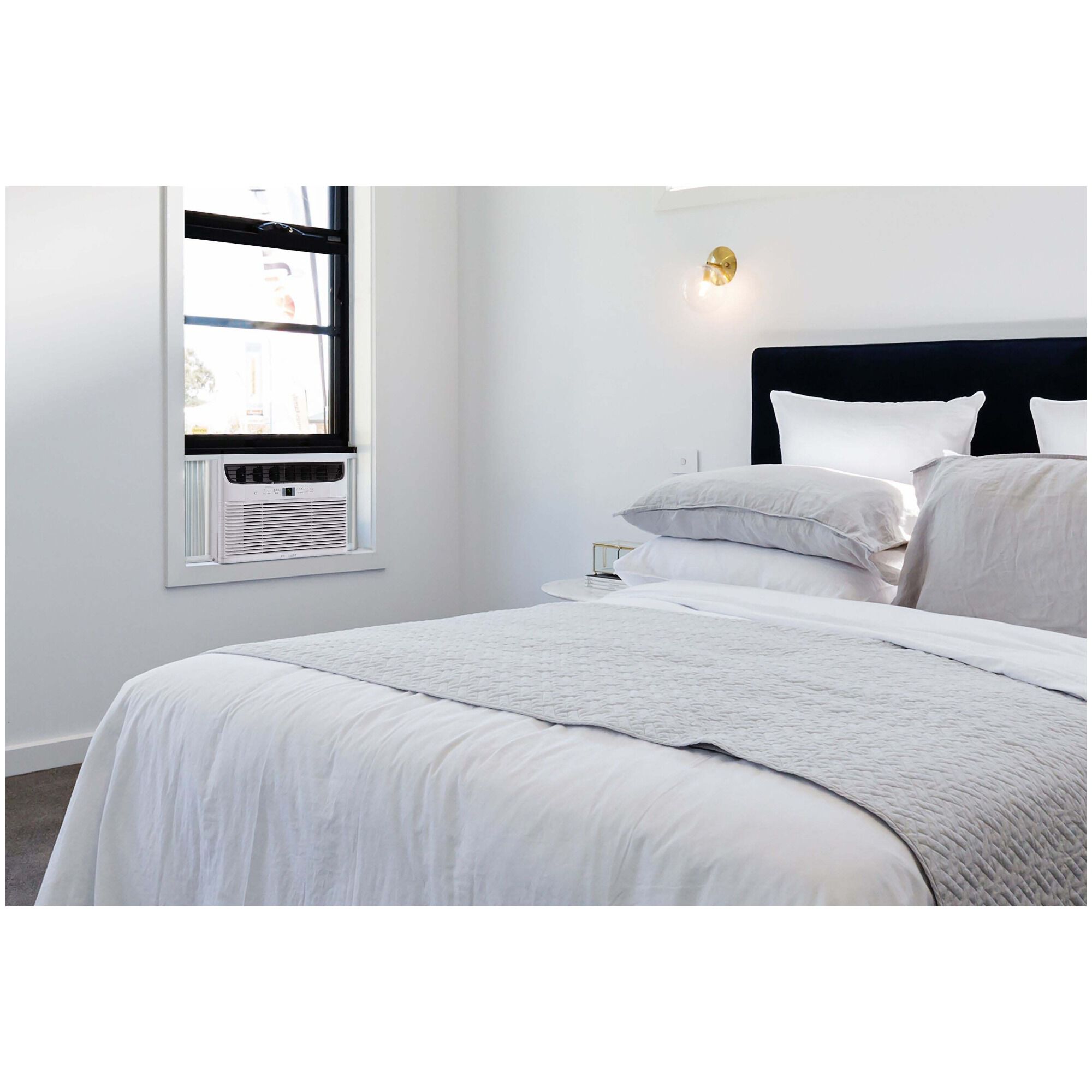 Frigidaire FHWC063TC1 window air conditioner installed in a bright bedroom window