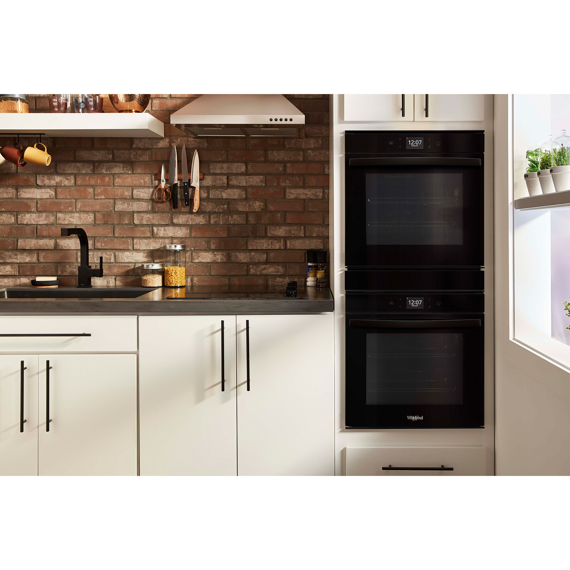 Whirlpool WOD52ES4MB 24-inch double wall oven installed in a modern kitchen with creme colored finished cabinetry.
