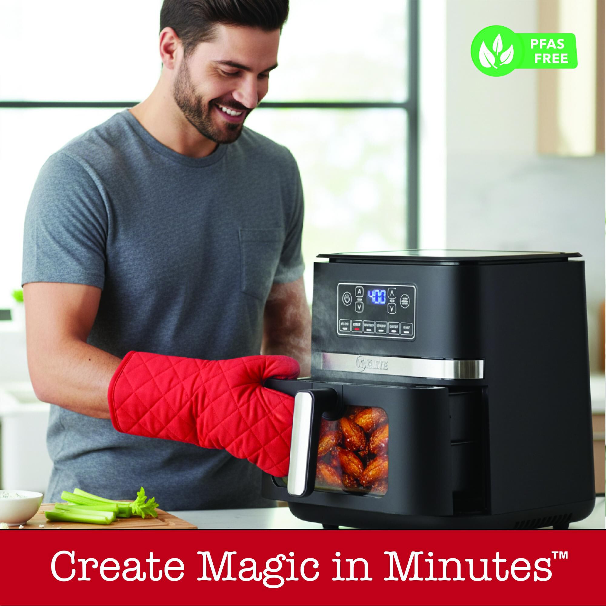 A smiling man wearing a red oven mitt opens a Kitchen Elite KE-AF-A102M 5-Quart Air Fryer containing cooked chicken wings. Text reads Create Magic in Minutes. PFAS Free logo displayed.