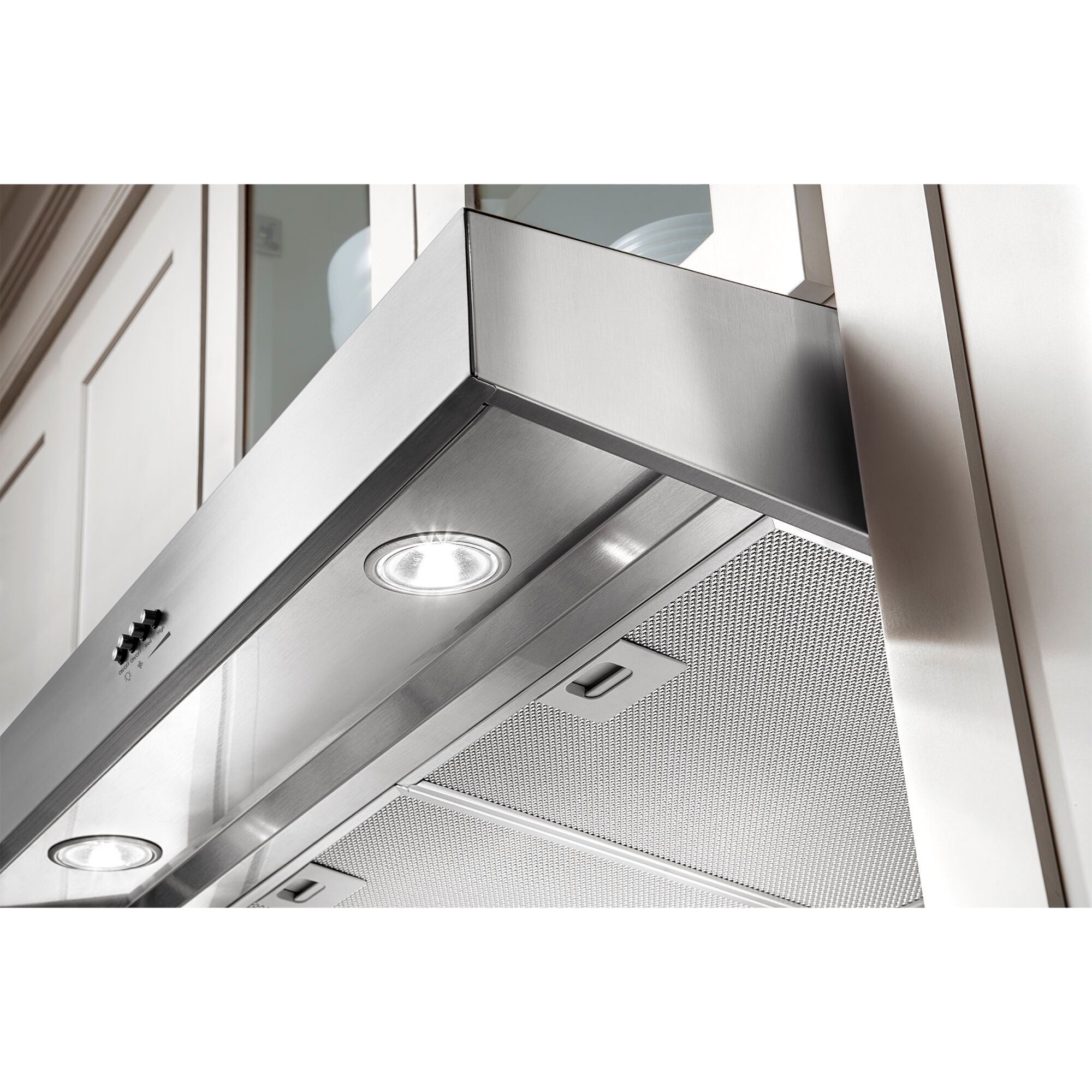 Whirlpool WVU37UC6FS range hood installed over a cooktop with interior lighting illuminating the cooking surface below.