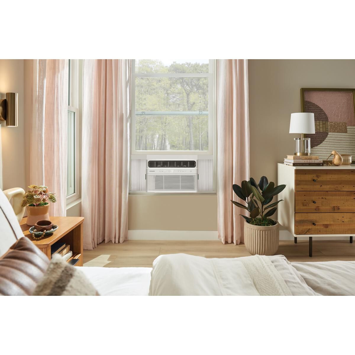 Frigidaire FHWW125WE1 window air conditioner installed in a sunlit bedroom window.