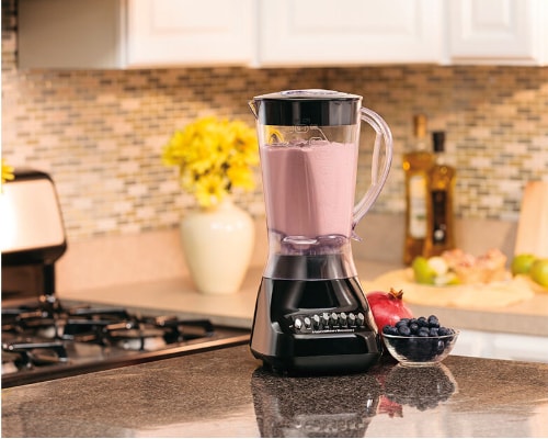Lifestyle image of Hamilton Beach 10-Speed Smoothie Blender sitting atop a kitchen counter filled with a blended fruit mix.