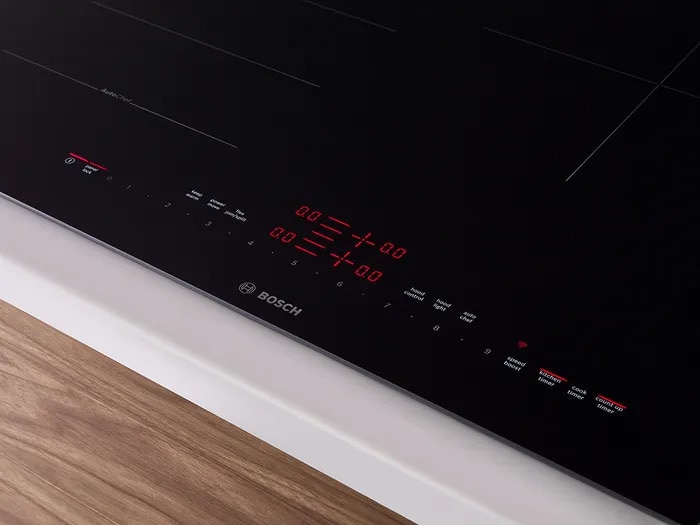 Close-up of Bosch NIT5060UC touch controls and digital display with illuminated red temperature settings.