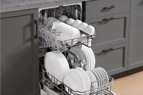 Midea 18-inch dishwasher with door open, showing upper and lower racks fully loaded with plates, cups, and silverware.