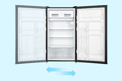 Compact refrigerator with reversible door feature shown open, displaying white interior with freezer compartment and shelves. Blue arrows indicate door can swing either direction.