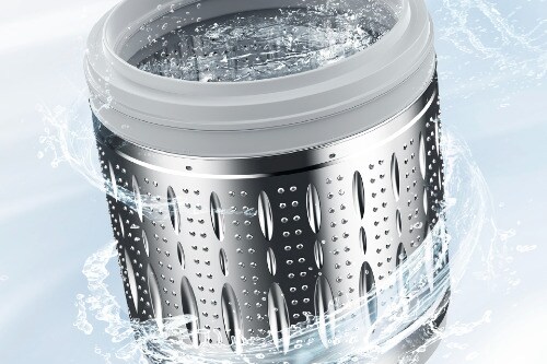 Close-up of Midea washer's stainless steel drum with perforated design and water spray, demonstrating the wash basket's durable construction and drainage system