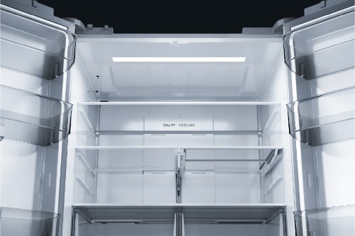IInterior view of empty Midea French door refrigerator with both doors open, showing bright LED lighting, multiple clear glass shelves, and 'Smart Cooling' label visible on the back wall.