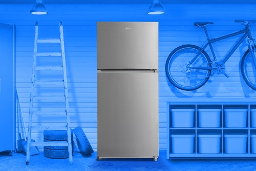 Midea 18 cu. ft. Top-Freezer Refrigerator model MRT18D3B shown in a garage setting with a blue overlay, surrounded by a ladder, tires, storage bins, and a bicycle mounted on the wall, emphasizing its garage-ready versatility.