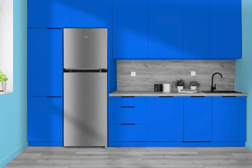 Midea 10 cubic foot stainless steel top-freezer refrigerator, model MRT10D3BST, installed in modern kitchen with vibrant blue cabinets, gray wood-look countertops, and minimalist design.