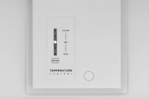 Close-up of Midea refrigerator's white temperature control panel with vertical sliding dial showing Colder, Mid, and Cold settings with adjustment button.