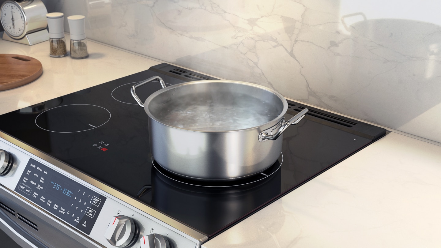 Close-up of Samsung electric range smooth glass cooktop with stainless steel pot showing steam, demonstrating instant direct heat induction cooking technology