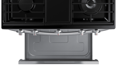 Close-up view of Samsung range's open bottom storage drawer with gray interior, showing spacious compartment beneath gas cooktop for storing cookware and baking sheets