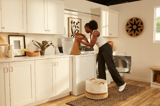 Speed Queen TR3006WN top load washer in a laundry room setting, showing its sturdy build and simple controls, with natural lighting and clean surroundings to highlight its practical, user-friendly design.