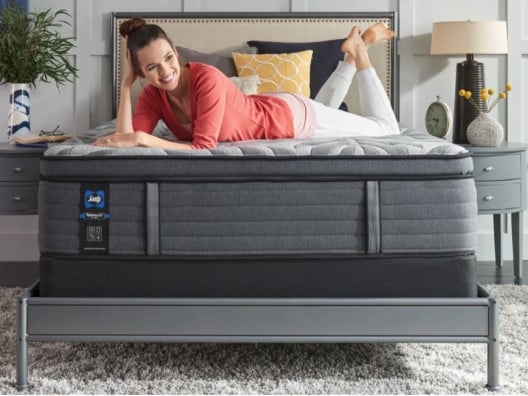 Woman Lounging on Bare Mattress in Bedroom