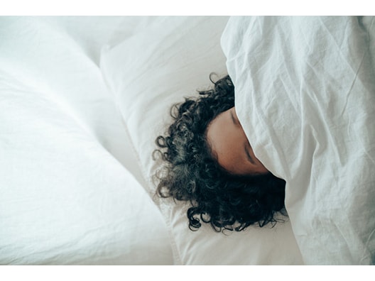 Curly Hair and Forehead Poking Out from Underneath Comforter