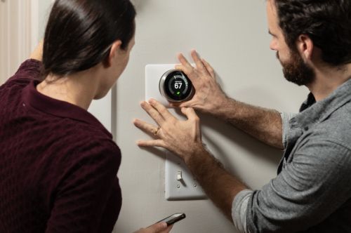 Man and Woman Installing Nest Thermostat