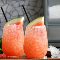 Two Festive Pink Drinks Garnished with Watermelon and Filled with Pellet Ice