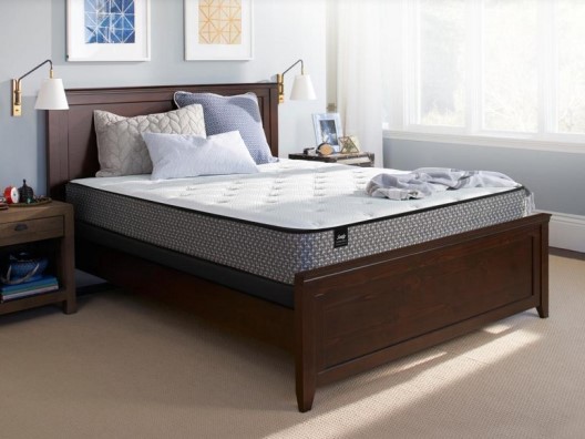 Bare Mattress on Brown Wooden Bedframe with Pillows on Top in Bedroom