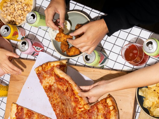 Overhead View of Table with Pizza, Wings, Chips, and Drinks