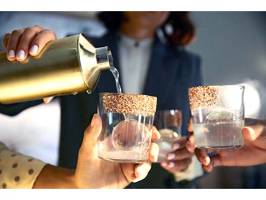 Woman Pouring Drinks into Glasses with Craft Ice