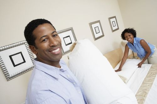 Couple making a bed 