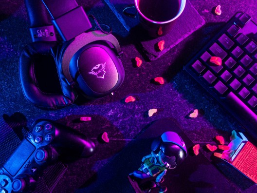 Gaming Controller, Keyboard, Headphones, Coffee Mug, and Scattered Cashews Illuminated by RGB Lighting