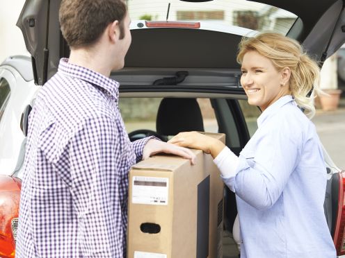 Man and Woman Loading TV Into Hatchback