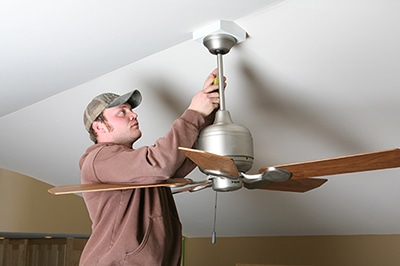 Man Repairing Brown Ceiling Fan