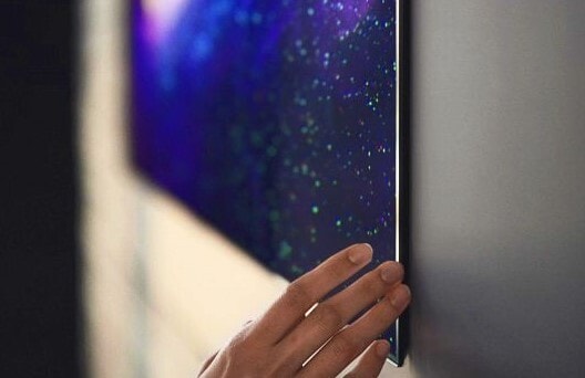 Hand Touching Corner of an LG G1 Series TV