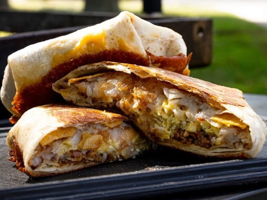 Stack of halved crunch wraps showing meat, cheese, and other delicious layered fillings