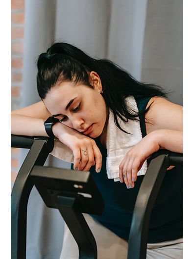 Woman Slumped Over on Exercise Machine