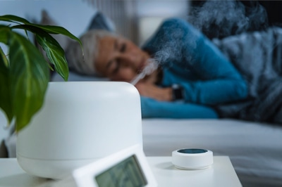 Humidifier on Nightstand with Sleeping Woman in Background
