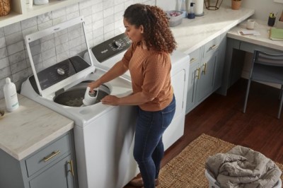 Woman removing agitator from inside of washer