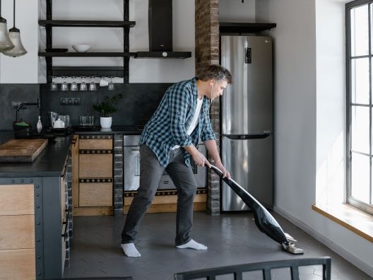 Man in Kitchen Cleaning Floor with Steam Mop