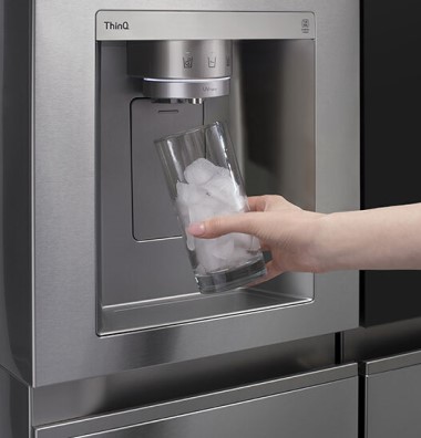 Hand Holding Glass Under Refrigerator Ice Dispenser