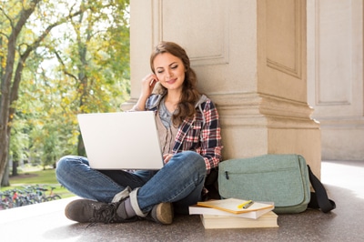 Young Woman Outside on Campus with Laptop