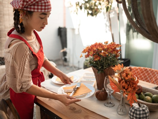 Young Woman Setting Table for Thanksgiving