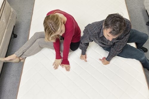 Couple testing a mattress in store