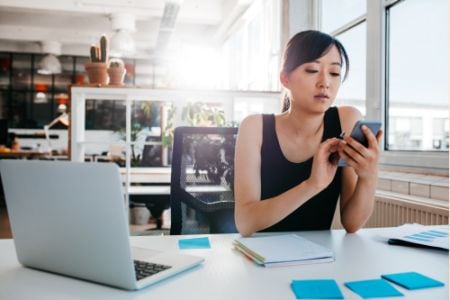 Woman Looking at Smartphone at Work