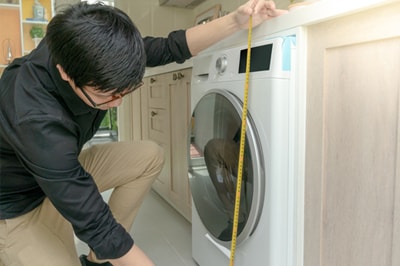 Man Measuring Washer with Tape Measure