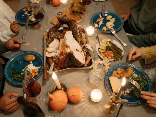 Thanksgiving Dinner Table with Half-Eaten Turkey and Plates with Scraps