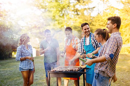 People gathered around a BBQ for a party 