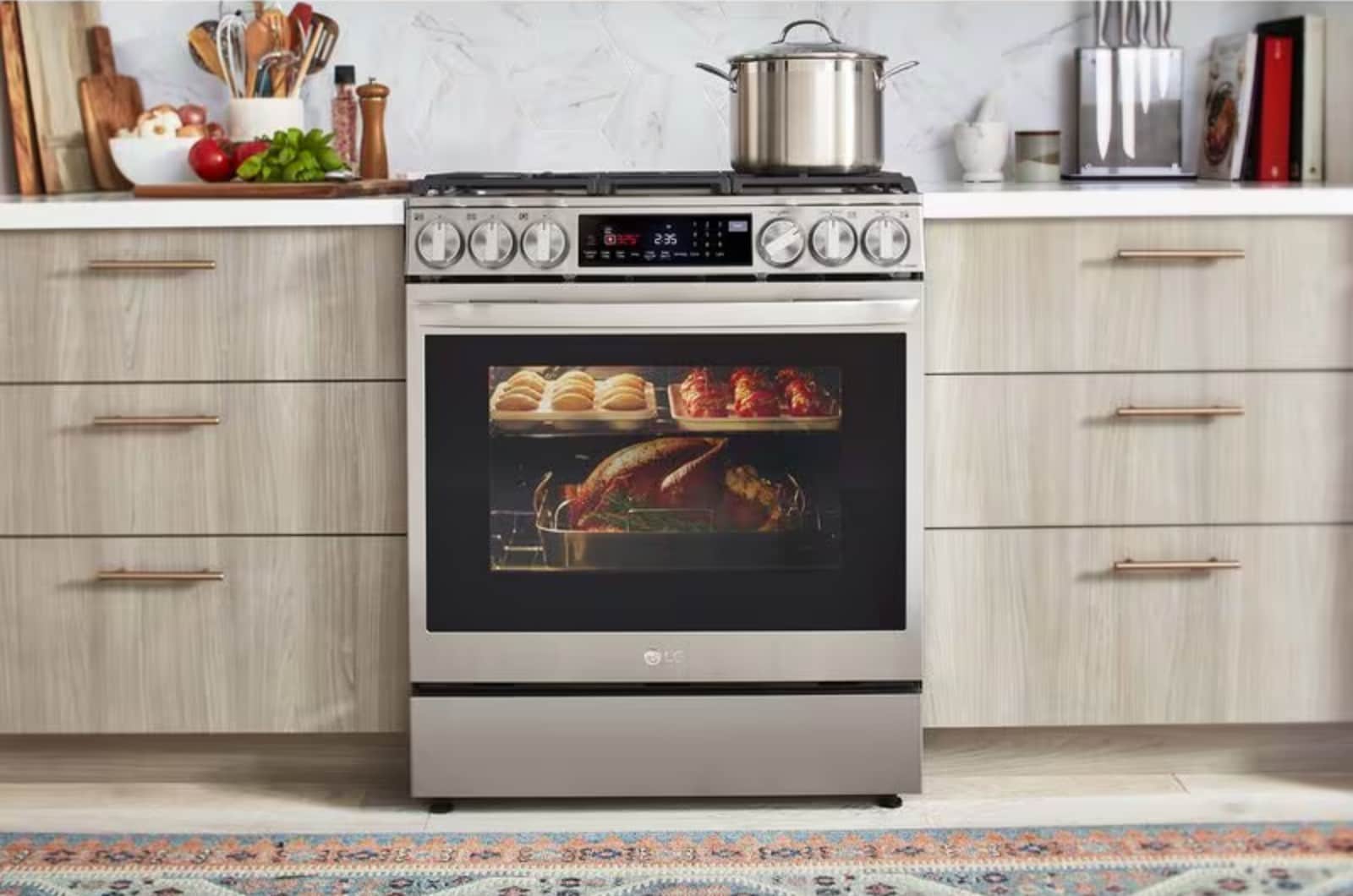 LG Instaview Gas Range model LSGL6335F, lifestyle image in kitchen, oven window showing turkey, bread rolls, and apples cooking