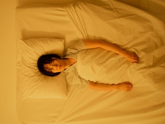 A cranky woman lying awake in bed