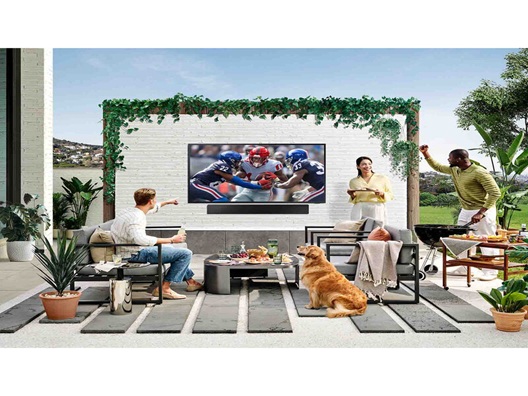 A group of people out on a patio watching a football game.