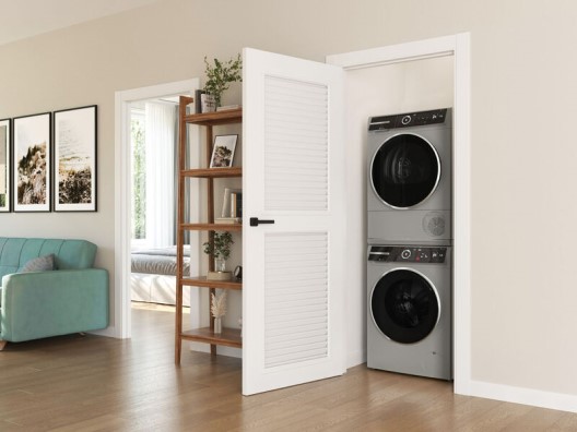 A washer and dryer stacked inside a hallway closet