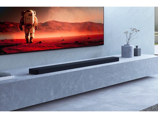A soundbar positioned underneath a TV.