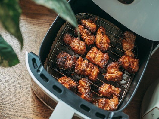 An overhead view of cooked chicken in an air fryer.
