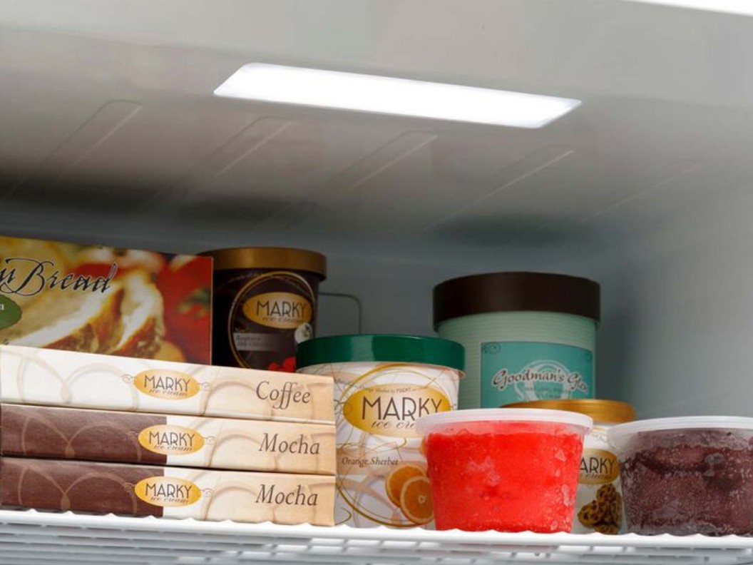 An image of a shelf in a freezer holding multiple frozen foods.
