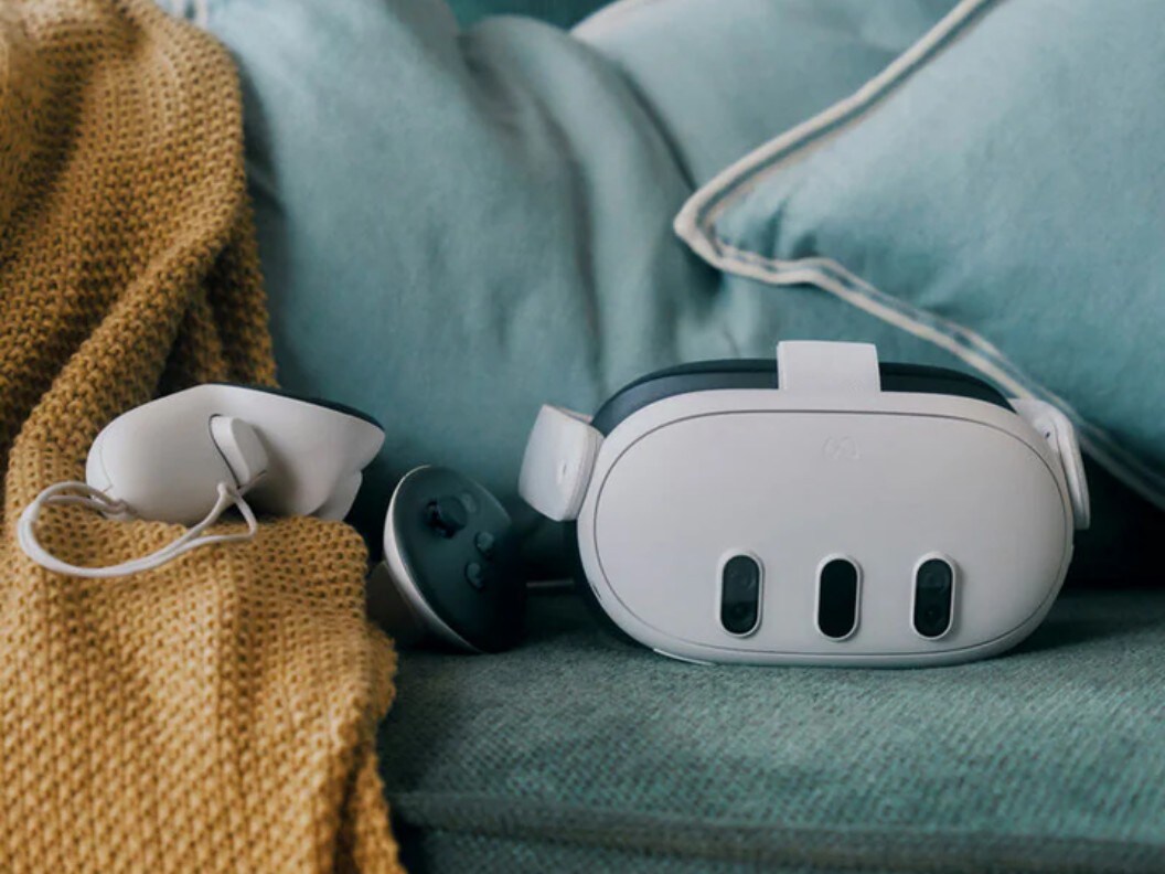 An image of a VR headset and its controllers on a couch.